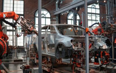 gray vehicle being fixed inside factory using robot machines