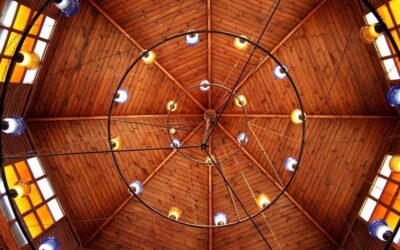Vue du plafond en bois avec chandelier circulaire et lumières colorées